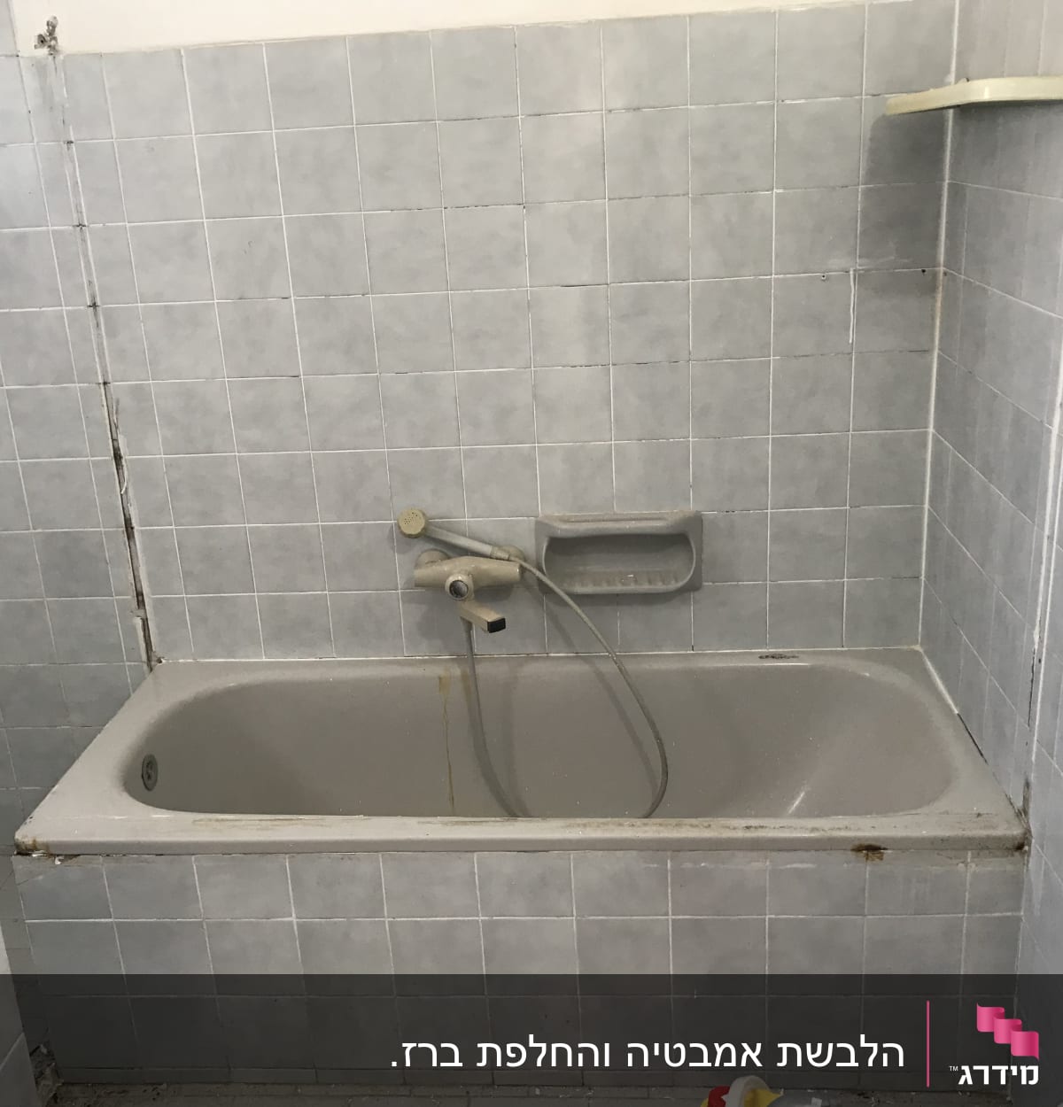 אמבטיה עם אריחים אפורים, ברז ומדף קטן